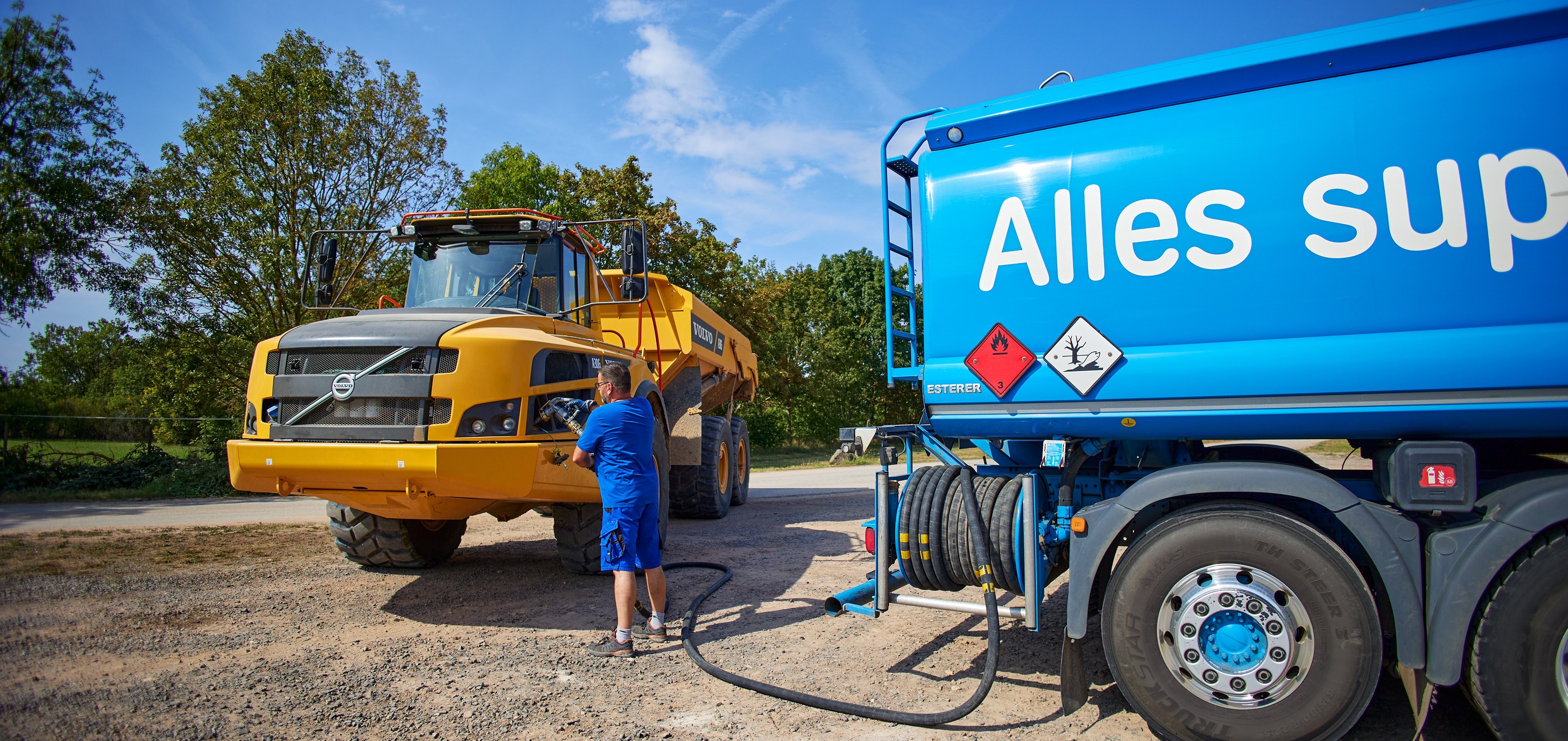 Ein Mitarbeiter versorgt Baumaschinen mit neuem Kraftstoff