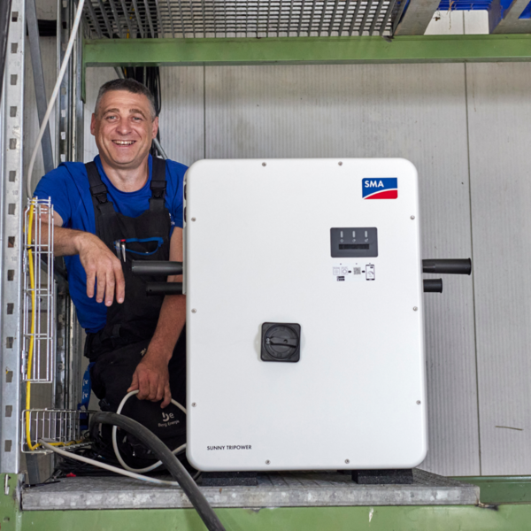 Mitarbeiter neben SMA SUNNY TRIPOWER Solarwechselrichter
